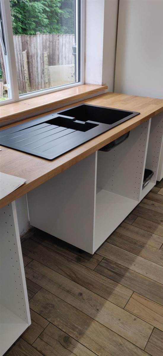During — black granite sink dropped into oak worktop, carcasses in place, kitchen taking shape